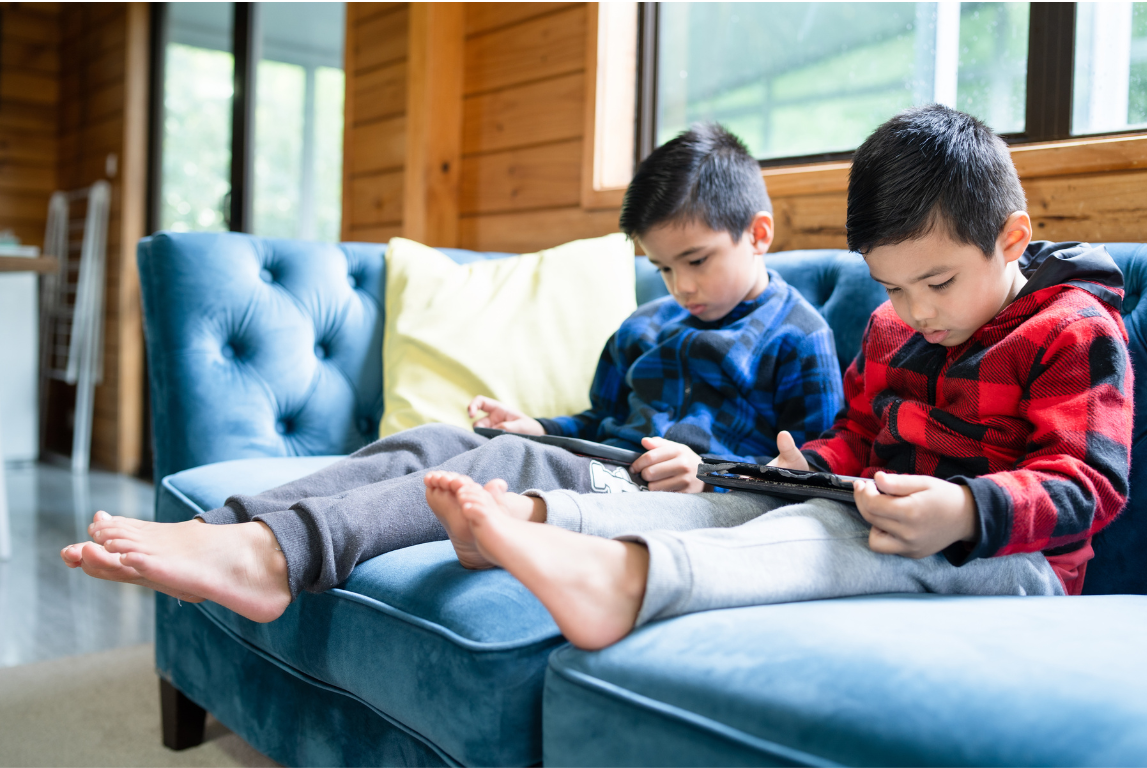 Dua orang anak kecil sedang menatap layar gadget dengan ekspresi serius